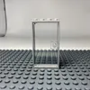 A transparent LEGO door with a gray frame is placed on a gray LEGO baseplate. Podgląd zdjęcia produktu