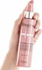 A hand holding a bottle of Kerastase Chroma Absolu Leave-In Serum. Produktbild-Vorschau