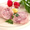 A close-up shot of sliced sausage with radishes, mustard, and parsley on a wooden board. Produktbild-Vorschau