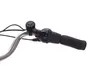 A close-up view of a bicycle handlebar with a grip, bell, and gear shifter. Produktbild-Vorschau