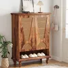 A wooden shoe cabinet with rattan doors is shown in a hallway, with shoes on the bottom shelf and a plant and lamp on top. Anteprima dell’immagine prodotto
