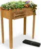 A wooden raised garden bed filled with plants and flowers, with a rolled-up black mat on the ground below. Anteprima dell’immagine prodotto