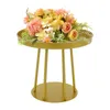 A gold side table with a floral arrangement on top, set against a white background. Podgląd zdjęcia produktu
