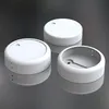 Three white cylindrical objects are arranged on a reflective gray surface. Produktbild-Vorschau