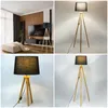 A collage of four images showing a tripod floor lamp with a black shade and wooden legs, displayed in different settings and close-ups. Podgląd zdjęcia produktu