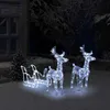 Christmas decorations of illuminated reindeer and sleigh in a snowy yard at night. Podgląd zdjęcia produktu