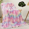 A soft, colorful blanket with a unicorn pattern draped over a chair, with a cloud-shaped decoration on the wall behind it. Náhľad obrázku produktu