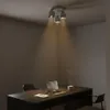 A dimly lit office or study room with a desk, laptop, and a ceiling light. Produktbild-Vorschau