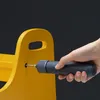A hand is using a gray cordless screwdriver to screw into a yellow object. Voir les images du produit