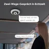 A woman is looking up at a ceiling-mounted camera, with speech bubbles indicating a two-way conversation. Produktbild-Vorschau