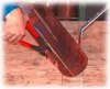 A person is using a pair of pliers to bend a copper gutter on a wooden surface. Náhľad obrázku produktu