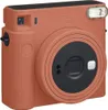 A close-up studio shot of a terracotta orange Fujifilm Instax Square SQ 1 instant camera against a white background. Anteprima dell’immagine prodotto