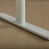 A close-up view of the white base of a desk leg on a wooden floor. Náhľad obrázku produktu