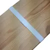 A white elastic strap with velcro fastening is attached to a wooden surface. Produktbild-Vorschau