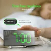 A person's hand is reaching for a digital alarm clock with a green LED display showing 7:00. Text overlays describe the product's features. Produktbild-Vorschau