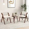 Two chairs and a small table in a room with a painting and a plant. Voir les images du produit