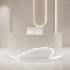 A modern, curved reception desk in a minimalist setting. Produktbild-Vorschau