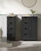Two dark gray storage cabinets are shown in a bathroom setting. The cabinet on the left is a narrow tower with four drawers. The cabinet on the right is wider, featuring five drawers on the left and a single cabinet door on the right. Both have slatted dra Náhled obrázku produktu