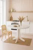 A white round dining table with a wooden chair next to it, set in a bright kitchen. Produktbild-Vorschau