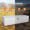 A diamond plate aluminum truck box is shown in a split image. The left side shows the box in a dry, outdoor environment with text highlighting its features. The right side shows the box in a rainy environment, with a truck in the background, emphasizing it Podgląd zdjęcia produktu