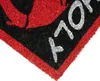 A close-up view of a doormat with a red border and black and red design. Produktbild-Vorschau