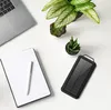 A flat lay of a desk with a laptop, notebook, pen, solar power bank, and plants. Produktbild-Vorschau