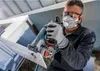 A man is using an angle grinder to cut a piece of material. Voir les images du produit