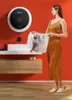 A woman is holding a laundry basket in a modern bathroom with a wall-mounted washing machine. Produktbild-Vorschau
