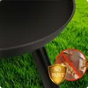 A close-up of a black fire pit on a grassy lawn, with a marketing overlay indicating 'NO RUST'. Náhľad obrázku produktu