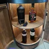 A wooden barrel converted into a bar with bottles of alcohol displayed on shelves. The barrel has doors that are open, revealing the interior with interior lighting. Náhled obrázku produktu