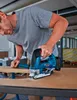 A person is using a blue and black jigsaw to cut a piece of wood. Anteprima dell’immagine prodotto