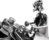 A close-up of a metal sculpture depicting a dentist examining a patient's teeth. Anteprima dell’immagine prodotto