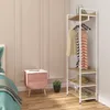 A bedroom corner with a nightstand and a clothing rack. Náhľad obrázku produktu