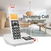 A cordless phone on its base, placed in a modern living room or dining area. Produktbild-Vorschau