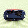 The underside of a vintage tin toy car is shown on a striped green and white background. Produktbild-Vorschau