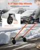A person is using a wheeled snow shovel to clear snow from a driveway in front of parked cars. Náhľad obrázku produktu
