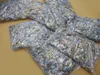 Several clear plastic bags filled with puzzle pieces are spread out on a tan surface. Produktbild-Vorschau