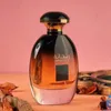 A bottle of Rihanna perfume is displayed on a pink and orange surface, with dried flowers and decorative items in the background. Voir les images du produit
