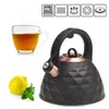 A black kettle with copper accents, a glass cup of tea, a lemon, and mint leaves, set against a white background. Icons indicating product features are displayed at the top. Produktbild-Vorschau