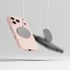 A pink iPhone case with a magnetic ring is shown suspended by white strings against a light gray and white background. A blurred, dark object is visible in the midground. Produktbild-Vorschau