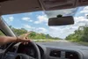 View from inside a car looking out the windshield at a road. Produktbild-Vorschau