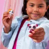 A young girl is holding two small toy animals. Náhled obrázku produktu