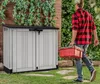 A man walks past a storage box carrying a red toolbox. Náhled obrázku produktu