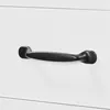 A close-up shot of a black drawer handle on a white surface. Produktbild-Vorschau