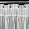 A close-up view of white sheer curtains hanging from a metal curtain rod. Produktbild-Vorschau