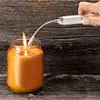 A hand is using a silver lighter with a flexible neck to light an orange candle in a glass jar. Anteprima dell’immagine prodotto