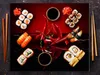 A top-down view of sushi, chili peppers, and soy sauce on a reflective surface. Náhled obrázku produktu