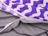 A close-up view of a duvet cover with a purple and white wavy pattern, showing the zipper closure. Produktbild-Vorschau