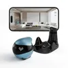 A blue and black robot pet with a charging dock and a smartphone displaying a live feed of a living room. Produktbild-Vorschau