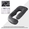 A dark gray U-shaped pillow is shown diagonally on a light gray and white background. Two small inset images show the fabric texture and the filling material. Produktbild-Vorschau